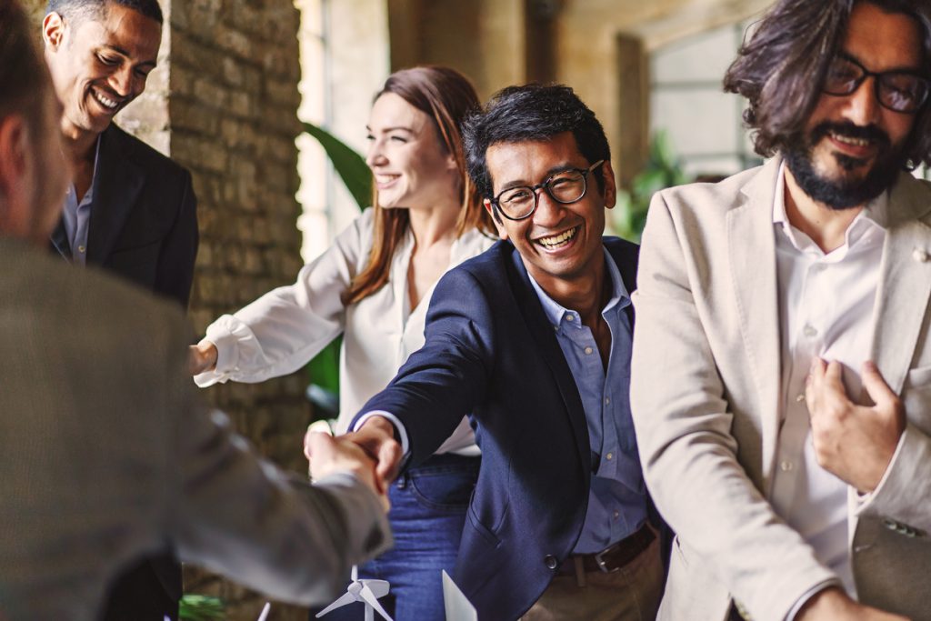 Professionals shake hands at a networking event in Atlanta.